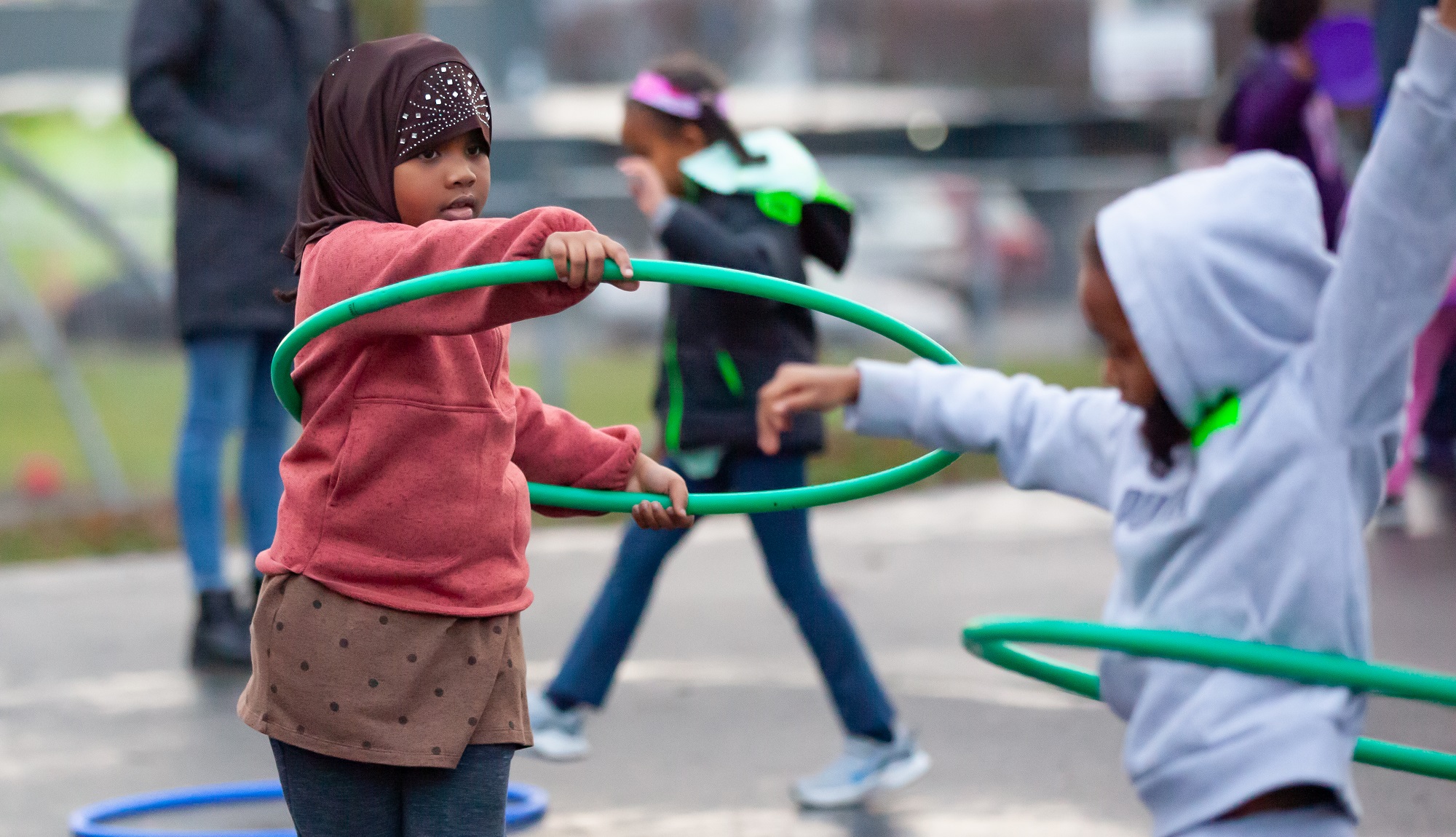 Students play with hula hoops at recess