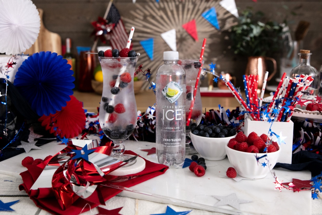 Sparkling Ice Patriotic Punch Cocktail on table surrounded by red, white, and blue banners and celebration material.