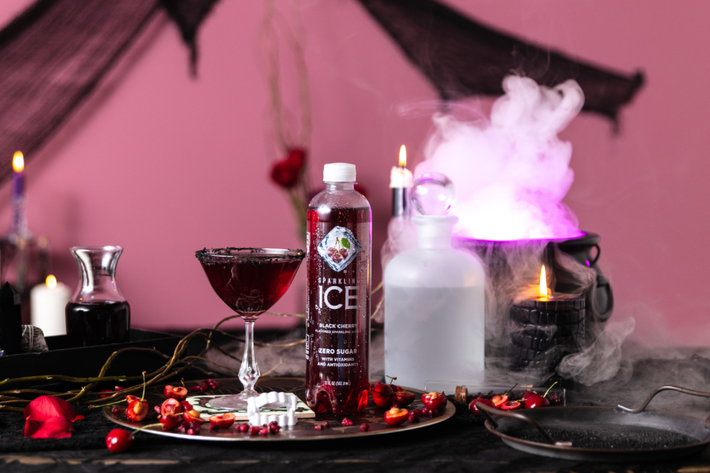 Sparkling Ice Vampire Bite Halloween margarita cocktail on table with pink smoke from dried ice.